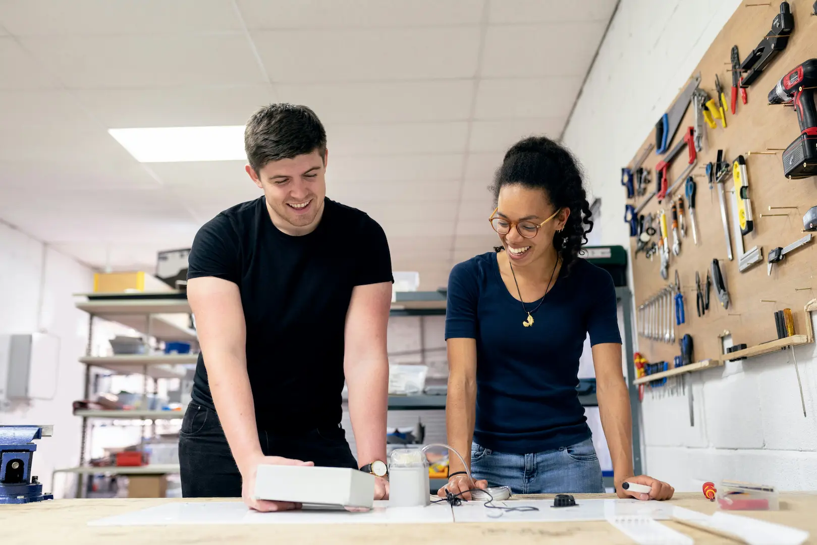 Man and woman working on prototype in workshop